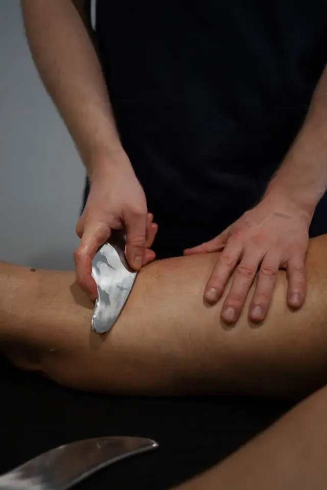 Masaje de pierna con herramienta metálica